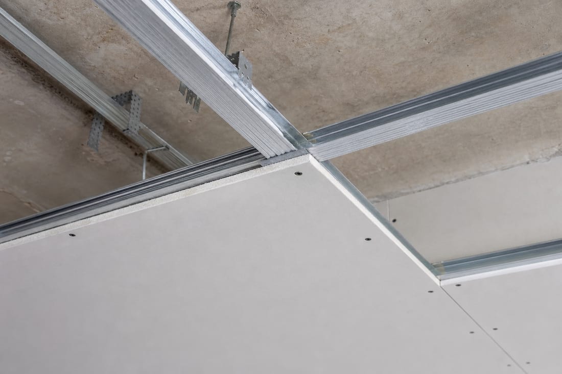 Exemple : ossature et plaque de faux plafond en cours de pose